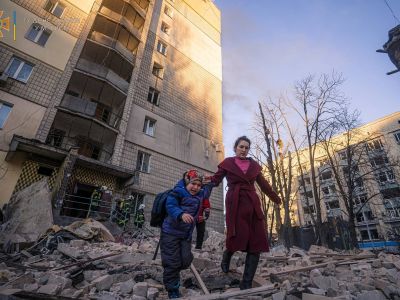 Женщина с ребенком эвакуируется из жилого дома в Киеве, пострадавшего в результате обстрела 16 марта 2022 года. Фото: Reuters